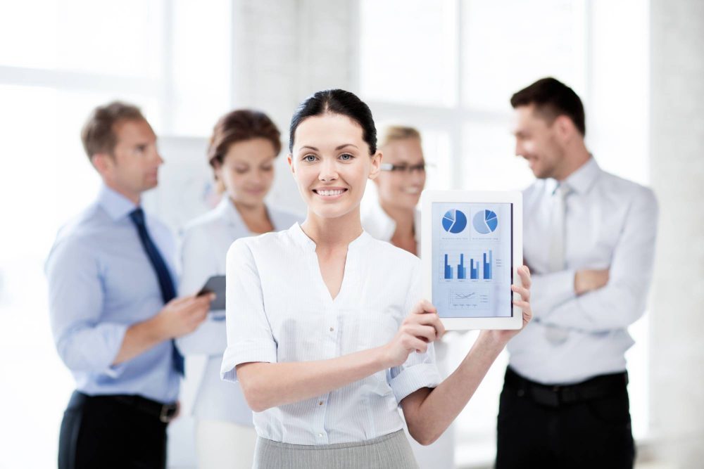 businesswoman showing tablet pc with graphs in office